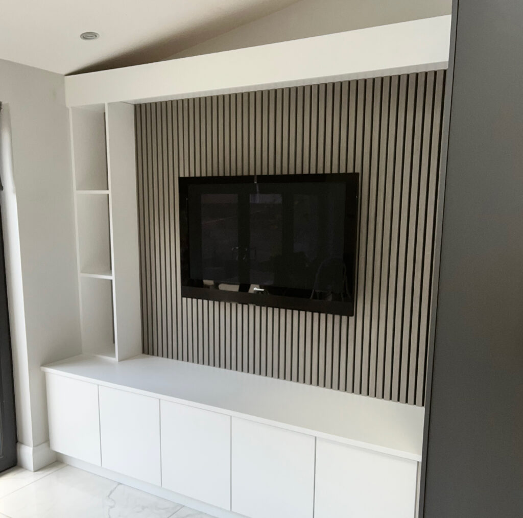 McIntyre Carpentry - bespoke white feature tv wall with shelving and cupboards
